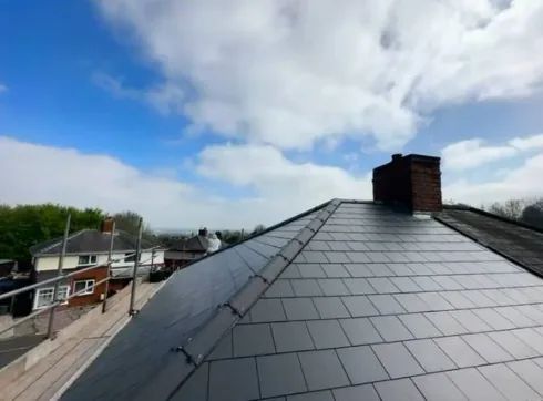 Grey slate pitched roof with chimney
